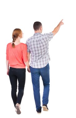 Back view of walking young couple (man and woman) pointing. clipart