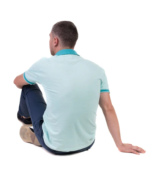 Back view of seated handsome man in polo looking up. — Stock Photo, Image