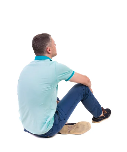 Back view of seated handsome man in polo looking up. — Stock Photo, Image