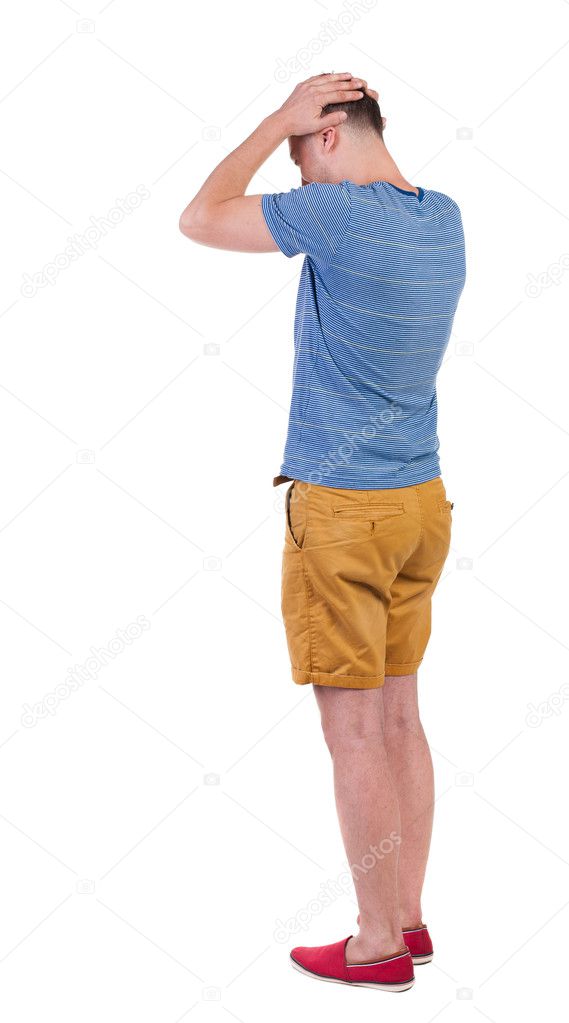 Back view of angry young man in shorts and t-shirt.