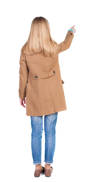 Vrouw in mantel wijzend op kopie ruimte — Stockfoto