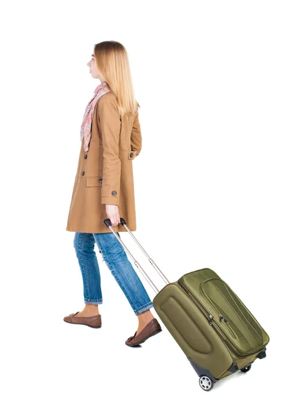 スーツケースを持つ女性の歩行の背面図 — ストック写真
