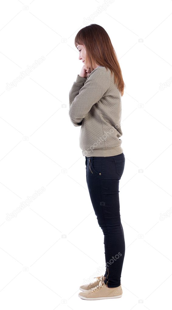 Girl standing sideways, wondering with fist on the cheek. 