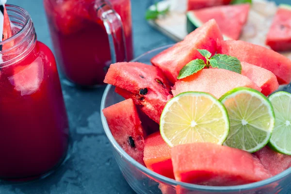 Watermelon slices with lime and smoothie on black table — Stock Photo, Image