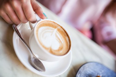 Kapuçino Kupası kız ellerinde. Kahvaltı.