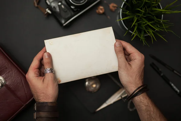 Foto vazia nas mãos sobre mesa de estilo vintage — Fotografia de Stock