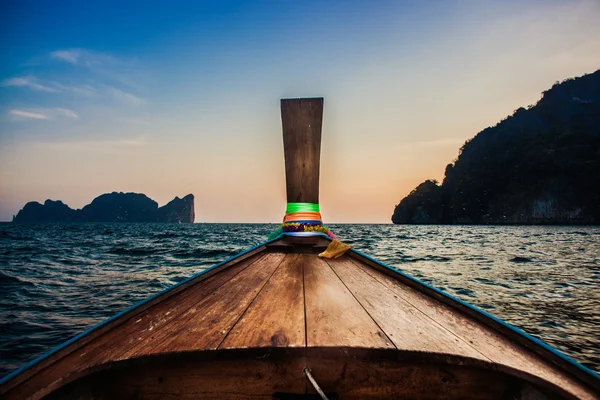 Prow wooden boat go to sunset in the sea — Stock Photo, Image