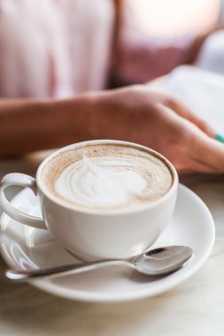 Kapuçino Kupası kız ellerinde. Kahvaltı.