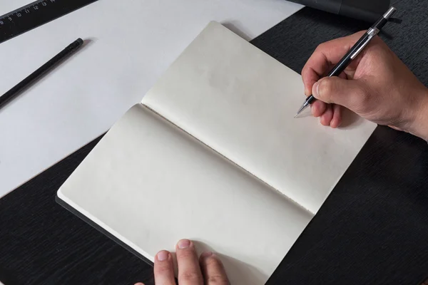 Man draws on a sketchbook