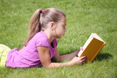 küçük kız açık havada bir kitap okuma