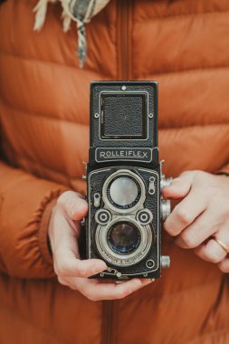 Güzel eski bir çift lensli fotoğraf makinesi Rolleiflex ile fotoğraf çekiyor.