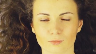 bir kızın yakın ' s yüz, Saçında beyaz bir arka plan esen rüzgar