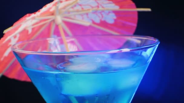 Rotationsfreudiger blauer Cocktail mit Regenschirm — Stockvideo