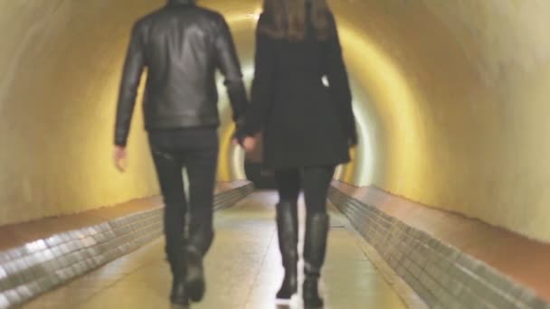 Een jong koppel gaat in tunnel — Stockvideo