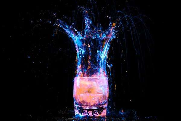 Glass with splashes and lemon — Stock Photo, Image