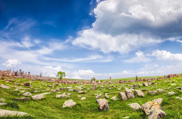 หินบนสนามหญ้าและท้องฟ้าเมฆที่งดงาม — ภาพถ่ายสต็อก