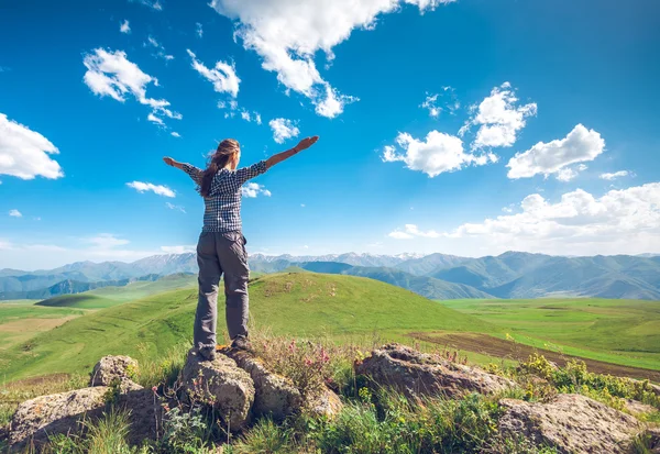 Woman with raised hands on hills — Stock Photo, Image