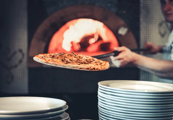 Koch zückt die fertige Pizza — Stockfoto
