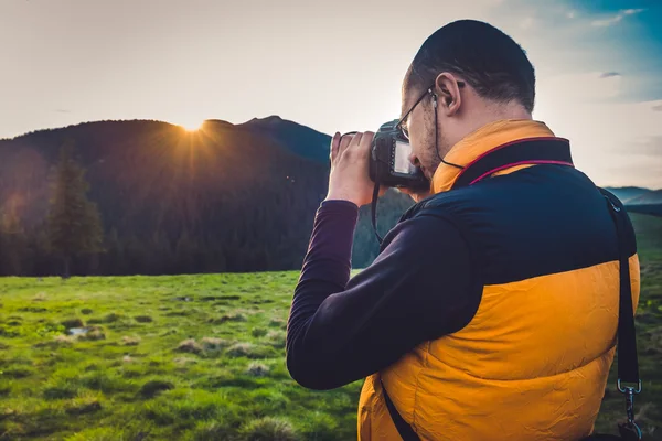 Homme avec appareil photo prenant des photos de montagnes — Photo