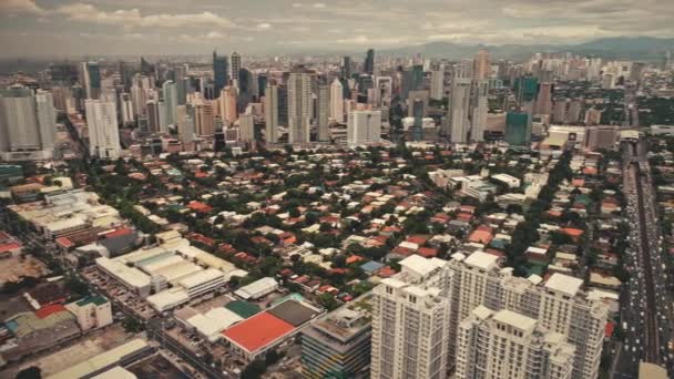 Moderne stadsgezicht met wolkenkrabbers, huisjes op de weg antenne. Filippijnen mijlpaal van metropool stad — Stockvideo