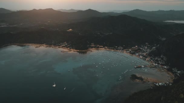 港湾都市の空中と海港で日の出。山系の緑の森の桟橋町 — ストック動画