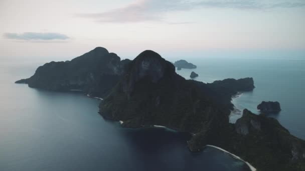 Salida del sol en el paisaje marino con isla de montaña aérea. El sol sale de la luz en la serena bahía oceánica. Islote de monte — Vídeo de stock