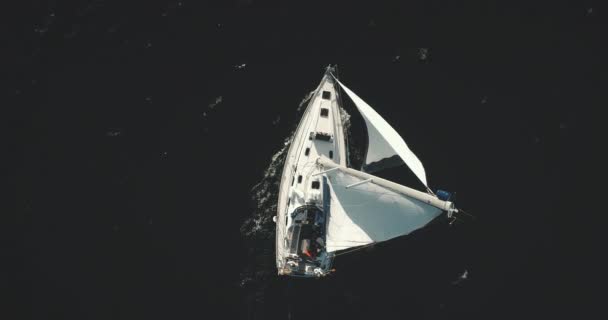 White sailing yacht top down aerial. Dramatic dark seascape with cruise of sailboat at open sea bay — Stock Video