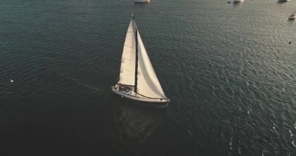 Lumina soarelui aerian deasupra suprafeței mării cu barca cu vele. Yacht croazieră pe apă senină. Vacanță de vară — Videoclip de stoc