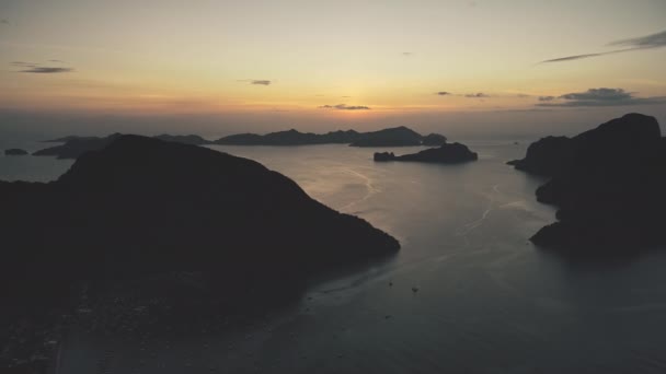 Ορεινό νησί σιλουέτα στον κόλπο του ωκεανού ηλιοβασίλεμα αργή κίνηση εναέρια άποψη. Tropic θαλασσογραφία στο ηλιοβασίλεμα — Αρχείο Βίντεο