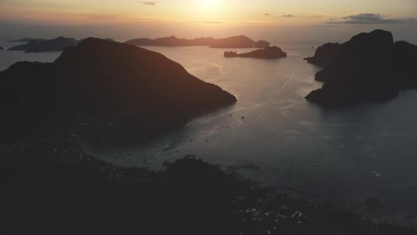 Sunset sziluett hegyi sziget Ocean Harbor, hajók légi. Naplemente a tengeri mólónál. — Stock videók