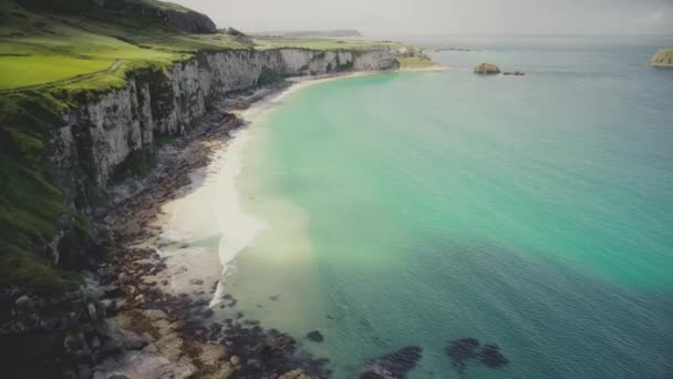 Atlantens azurblå vatten utsikt från luften. Vågor tvätta vit grotta stranden vid steniga strandklippor — Stockvideo