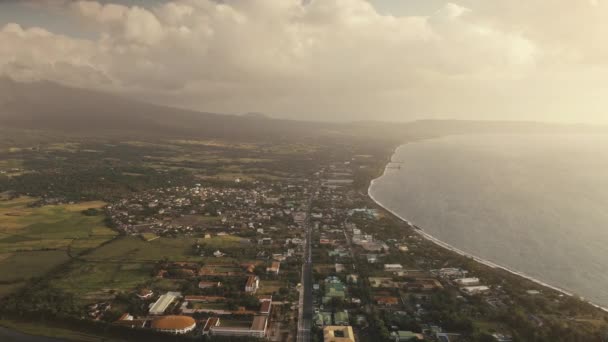 Aerial słońce krajobraz w zatoce oceanicznej. Miejska ulica z domami w zielonej dolinie. Tropikalny krajobraz przyrody — Wideo stockowe