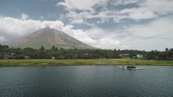 Volcan tropical au bord du lac aérien. Croisière touristique au bateau à la vallée de l'herbe verte au rivage — Video