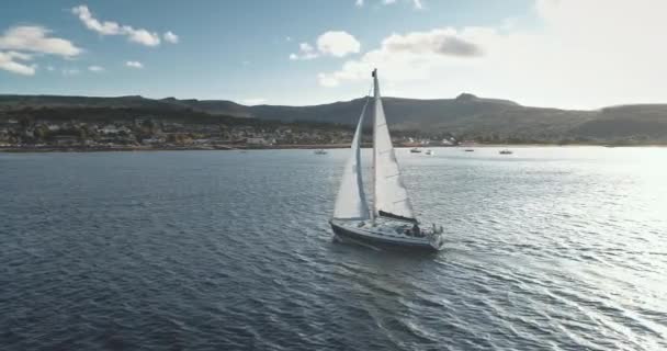 Slow motion sun reflection at sails of yacht aerial. Seascape with sailboat at ocean bay. Sea coast — Stock Video