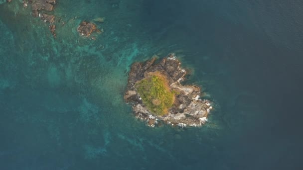 Arriba hacia abajo de la isla de roca con pico verde aéreo. Las olas del océano chocan contra acantilados. Nadie naturaleza paisaje marino — Vídeo de stock