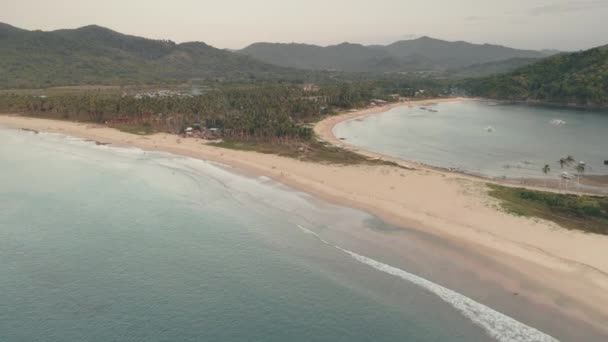 Tropické letovisko s turisty na písečné pláži antény. Pobřeží oceánu s letoviskem a domy — Stock video