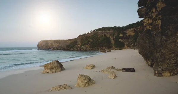 Sol ljus sand strand med havsvågor antenn utsikt. Vatten vid sandstrand med klippor och stenar — Stockfoto