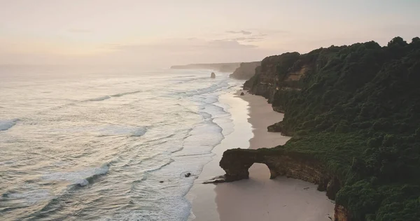 Soluppgång vid havet klippa strand med gigantiska hål vid bergvägg antenn utsikt. Tropiskt naturlandskap — Stockfoto