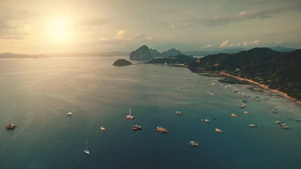 Solnedgång vid havsvik: båtar, båtar vid vatten. Havslandskap vid havskusten med sandstrand, grön palm — Stockfoto