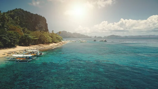 Sluneční písečná pláž na zeleném horském ostrově. Osobní lodě v tropické krajině — Stock fotografie