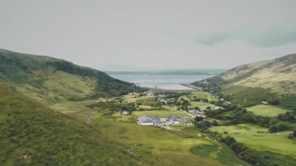Scozia villaggio a verde montagna valle aerea. Città collinare scozzese con lago di mare, rovine del castello — Video Stock