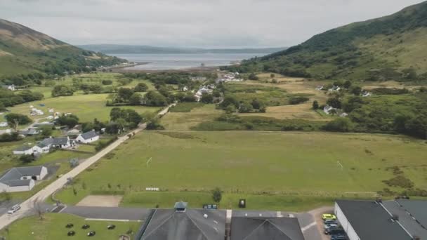Vallée de montagne verte village aérien. Paysage naturel écossais de la ville au lac de mer, ruines du château — Video