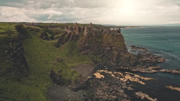 Παλιό κάστρο ερείπια στον ήλιο γκρεμό ωκεανού κεραία ακτή. Πράσινες κοιλάδες γρασίδι και λιβάδια στον κόλπο των ωκεανών — Αρχείο Βίντεο
