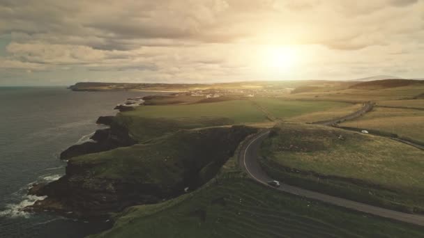 Campos verdes, prados aéreos. Los coches conducen por carretera. Irlanda colinas, tierras de cultivo en el día nublado — Vídeos de Stock