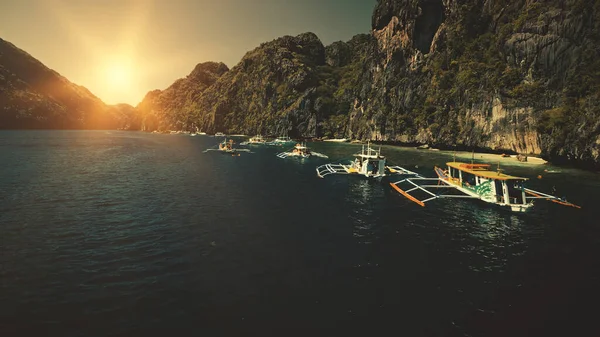 Paesaggio marino con barche passeggeri al tramonto in primo piano vista aerea. Costa scogliera con alberi al sole estate — Foto Stock