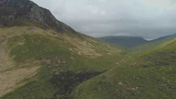 Herbe verte chaînes de montagnes aériennes. Chemin à la verdure montages herbeux. Nuages gris au-dessus de l'été — Video