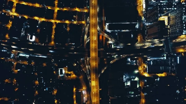 Autopista de tráfico nocturno de arriba abajo en la luz de la linterna con vista aérea del paisaje urbano. Crepúsculo iluminar — Foto de Stock