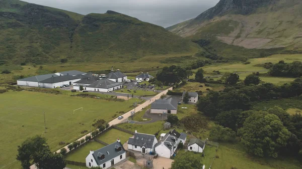 Aeronave de destilaria de uísque Arran. Estrada no vale das montanhas verdes. Aldeia escocesa com casas, acampamento — Fotografia de Stock