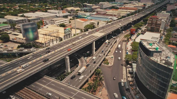 Moderner Wolkenkratzer an der Verkehrsstraße mit Autos. Manilas Innenstadt aus der Luft. Werbetafel im Stadtbild — Stockfoto
