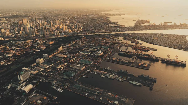 Puesta de sol en la ciudad portuaria de Metrópolis Manila en la bahía oceánica aérea. Luz solar en el puerto deportivo con barcos, barcos — Foto de Stock